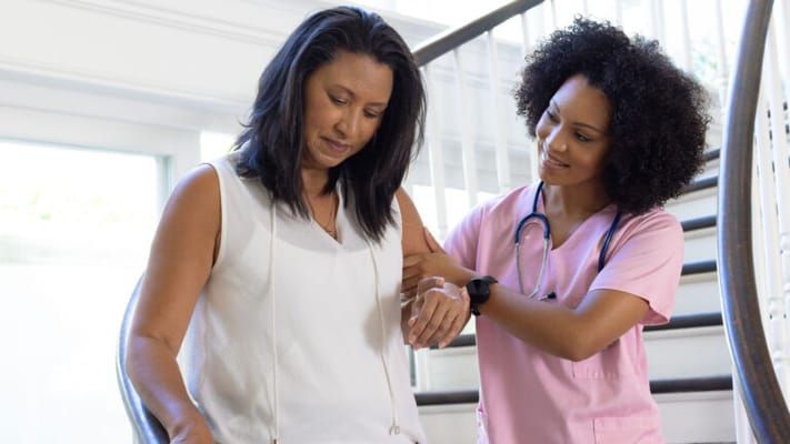 Healthcare worker assisting a resident on stairs