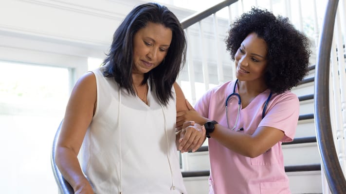 Healthcare worker assisting a resident on stairs