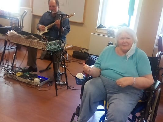 Resident enjoying music during a facility activity
