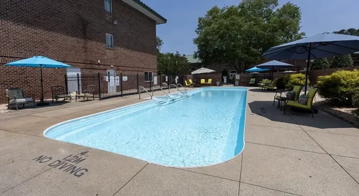 Outdoor pool area with lounge chairs and umbrellas
