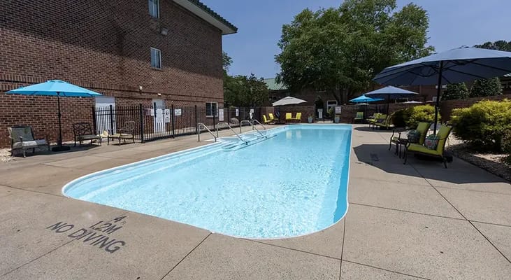 Outdoor pool area with lounge chairs and umbrellas