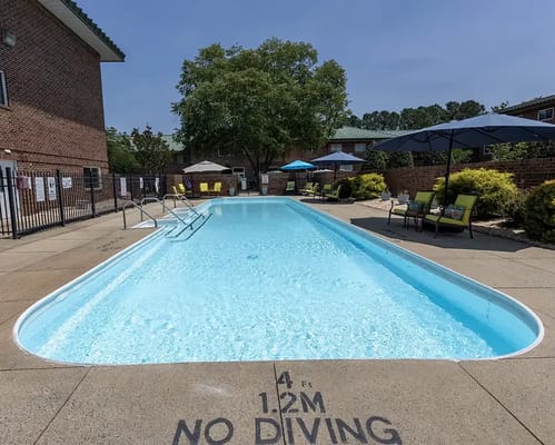 Swimming pool surrounded by lounge chairs and umbrellas