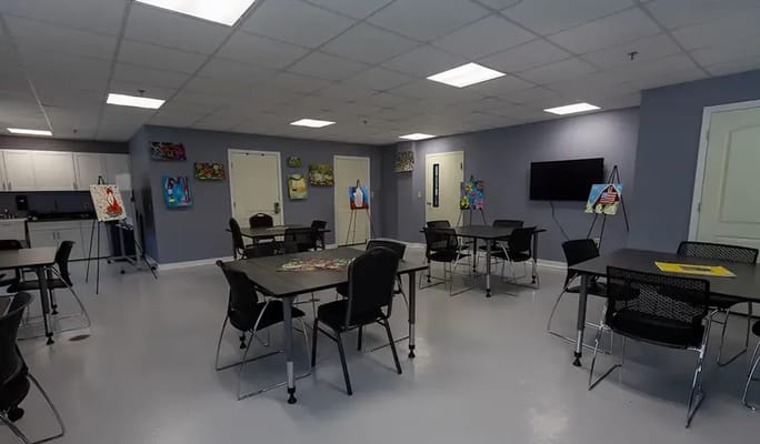 Art activity room with tables and artwork on display