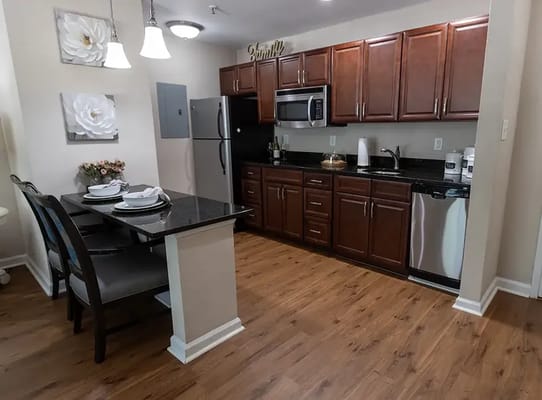 Modern kitchen with dining area in a senior living unit