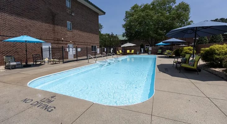 Swimming pool area with lounge chairs and umbrellas