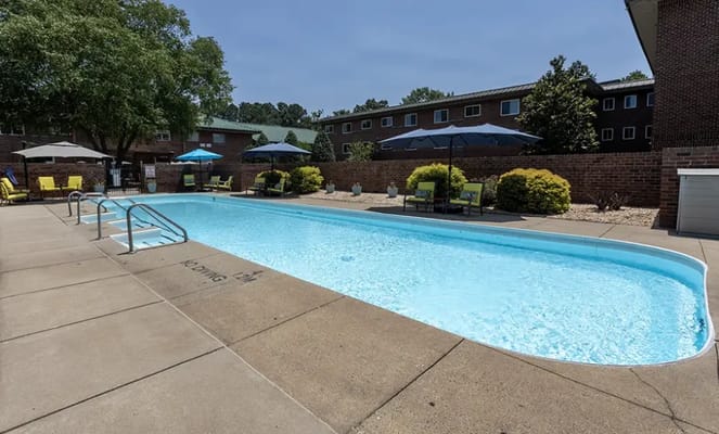 Outdoor swimming pool with lounge chairs and umbrellas