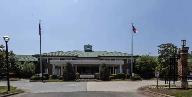Exterior view of a senior living facility with flags