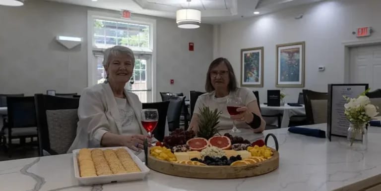 Two residents enjoying snacks and drinks in a dining area