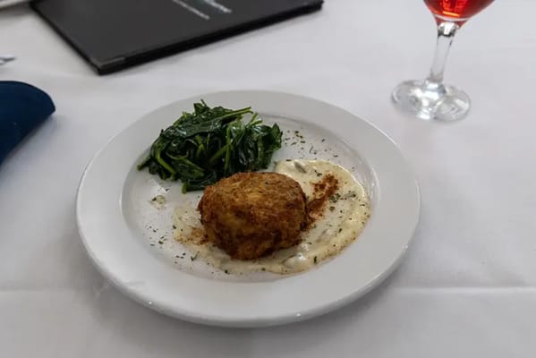 A plated meal with crab cake and spinach