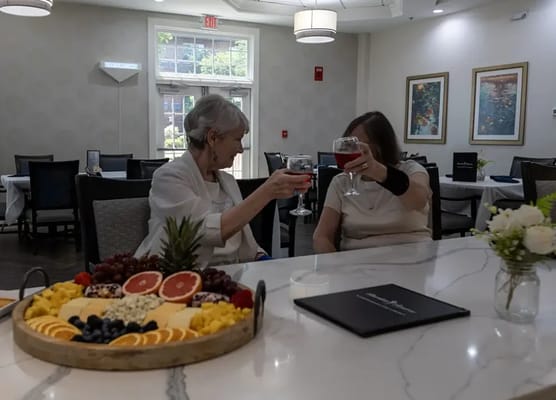 Residents toasting with drinks in a dining area