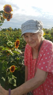 Senior woman in a sunflower field, enjoying the outdoors