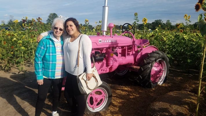 Senior resident with family member at a sunflower field