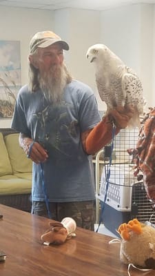 A resident interacting with a trained bird indoors