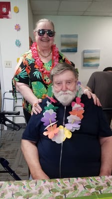 Residents celebrating with leis and sunglasses in an activity room