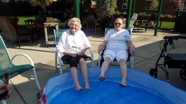 Two residents enjoying a foot soak in an outdoor area