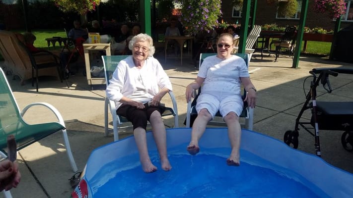 Two residents enjoying a foot soak in an outdoor area