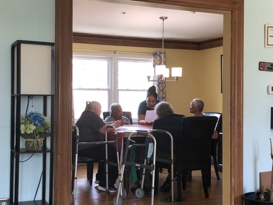 Residents and staff engaged in an activity in a bright room