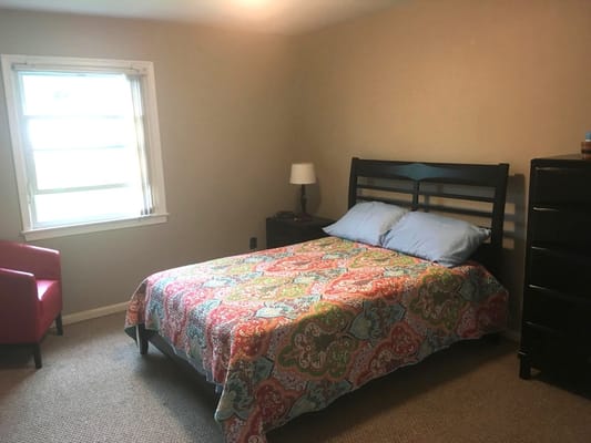 Bright private room with bed and chair