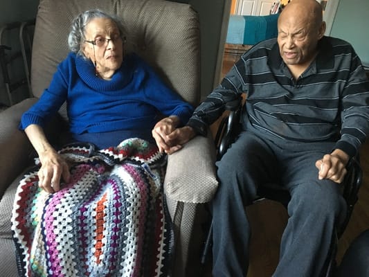 Two residents holding hands in a cozy lounge area