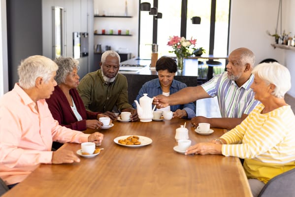 Residents enjoying tea and cookies in a communal area