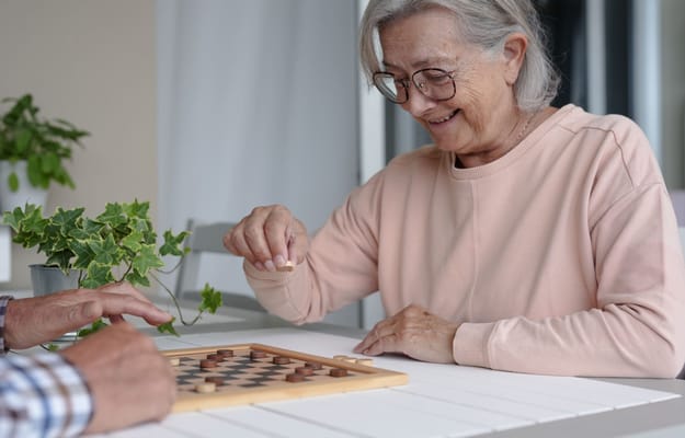 Residents enjoying a game of checkers at a table