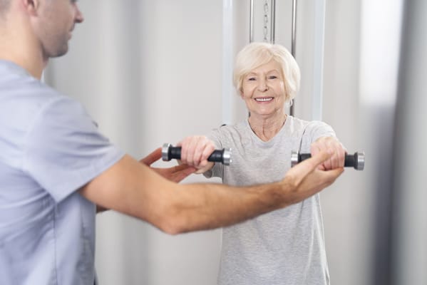Senior resident exercising with staff guidance