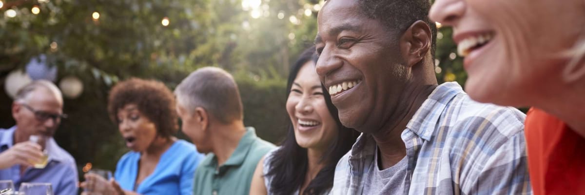 Residents enjoying a meal and conversation outdoors