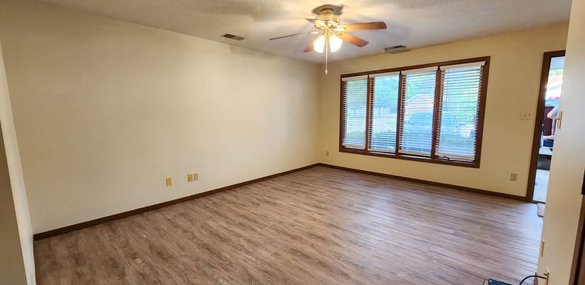 Empty interior room with windows and wooden flooring