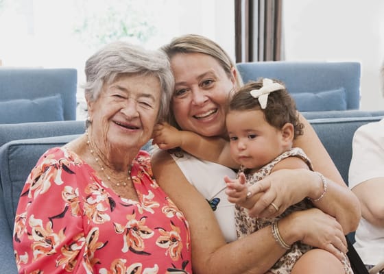 Residents and staff smiling together with a child