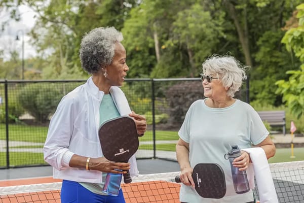 Two women enjoying a pickleball game in a park