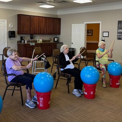 Residents participating in a drumming activity in the activity room