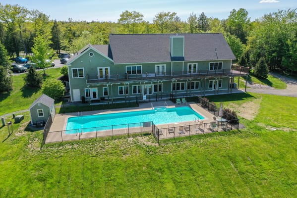 Aerial view of a facility with a pool and outdoor space