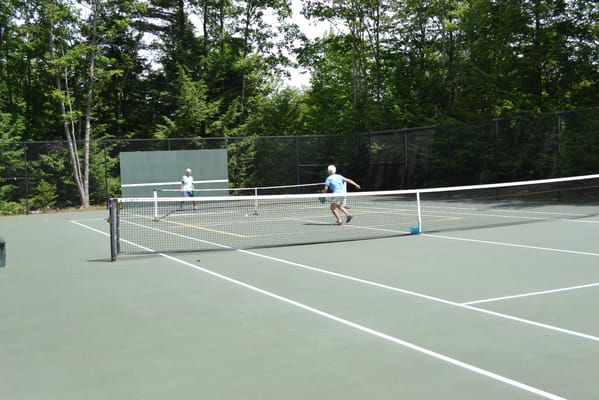 Residents playing tennis on an outdoor court