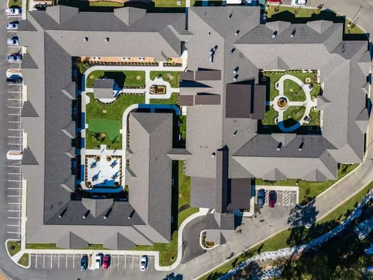 Aerial view of a senior living facility with landscaped gardens
