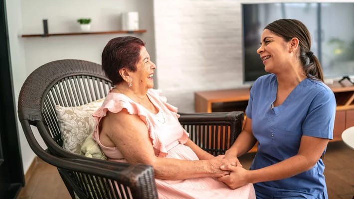 A caregiver and a resident sharing a joyful moment indoors