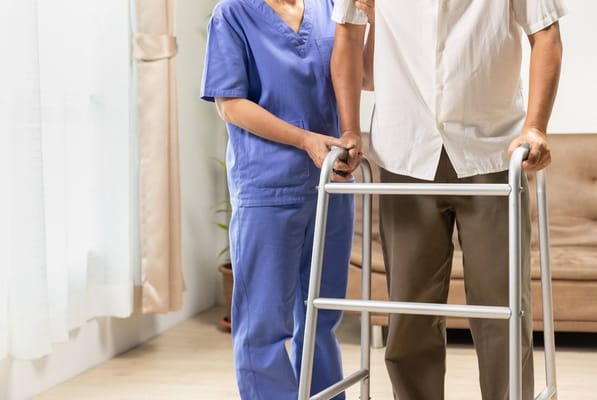 Healthcare worker assisting a resident with a walker