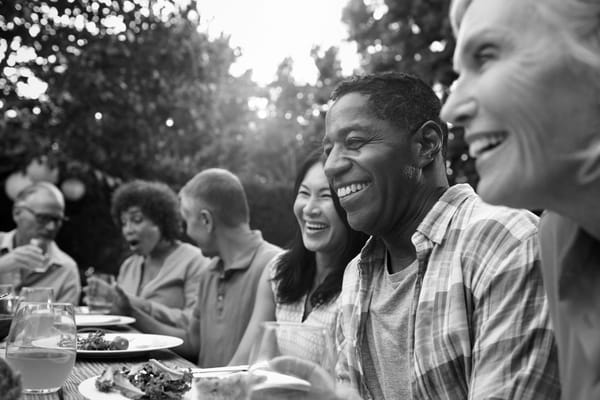 Residents enjoying a meal outdoors with laughter