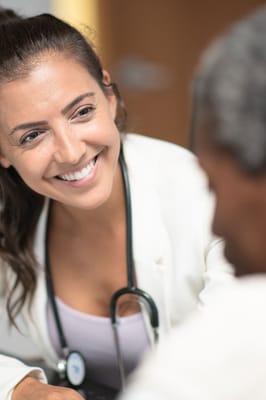 A healthcare professional smiling while interacting with a resident