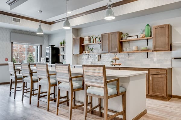 Bright common area with high stools and a kitchenette