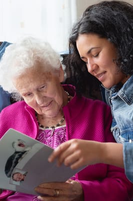 Resident looking at a photo album with a staff member