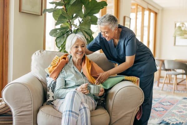 A caregiver assisting a resident in a cozy living area