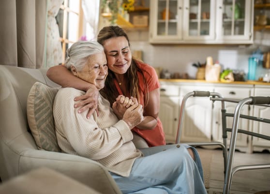 A caregiver hugging a resident in a cozy living space