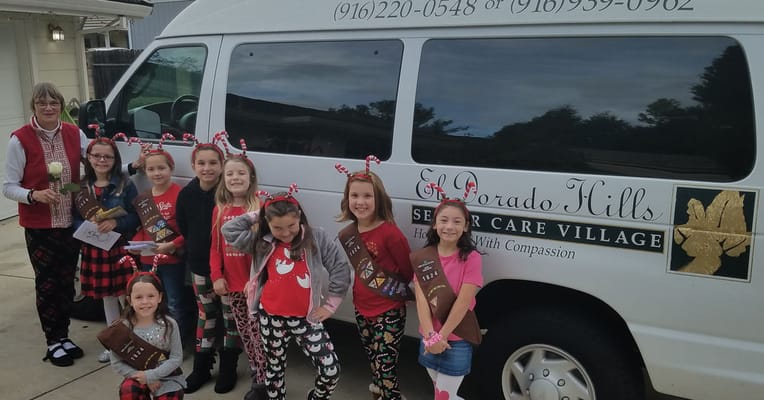 Group of children and staff by the facility vehicle