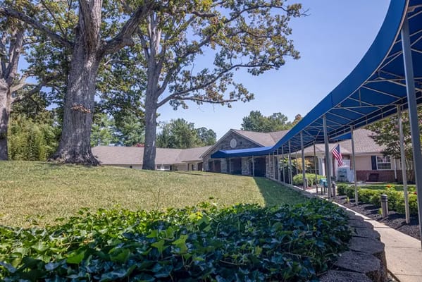 View of the facility exterior with a canopy and landscaping