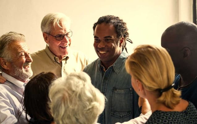 Group of residents and staff engaged in conversation