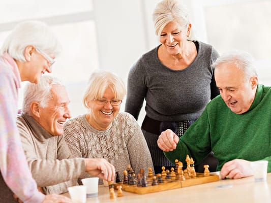 Residents and staff engaging over a game of chess