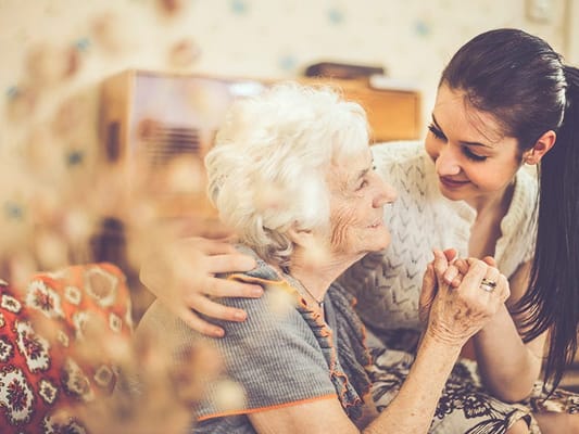 A caregiver with an elderly resident in a cozy interior setting