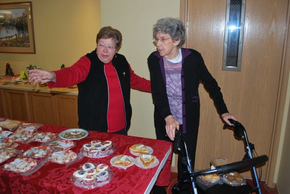 Residents and staff interacting at a dessert table