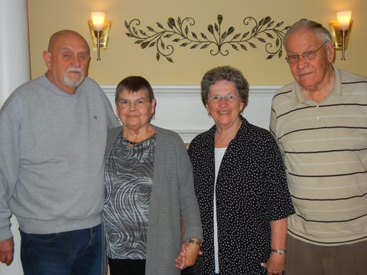 Four residents smiling in a common area