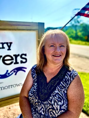 Woman smiling in front of a sign